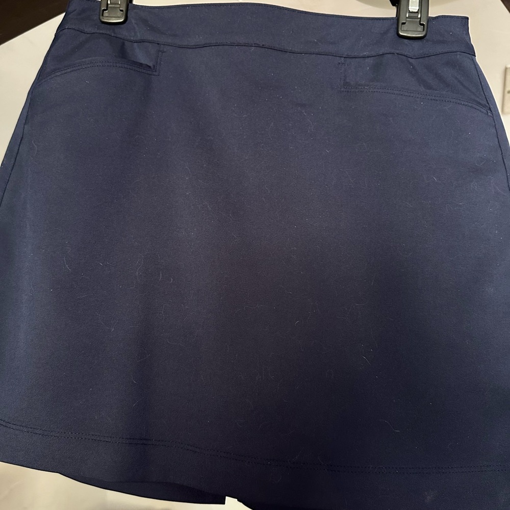 Navy Blue Skort. 2 slit pockets in front and one in back. Also zips in back.